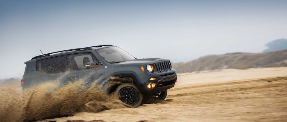 A silver 2018 Jeep Renegade driving through the sand dunes