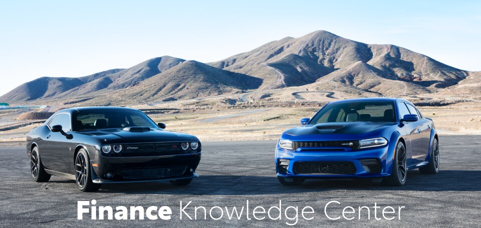 2 beautiful Dodge vehicles in front of some curvy hills