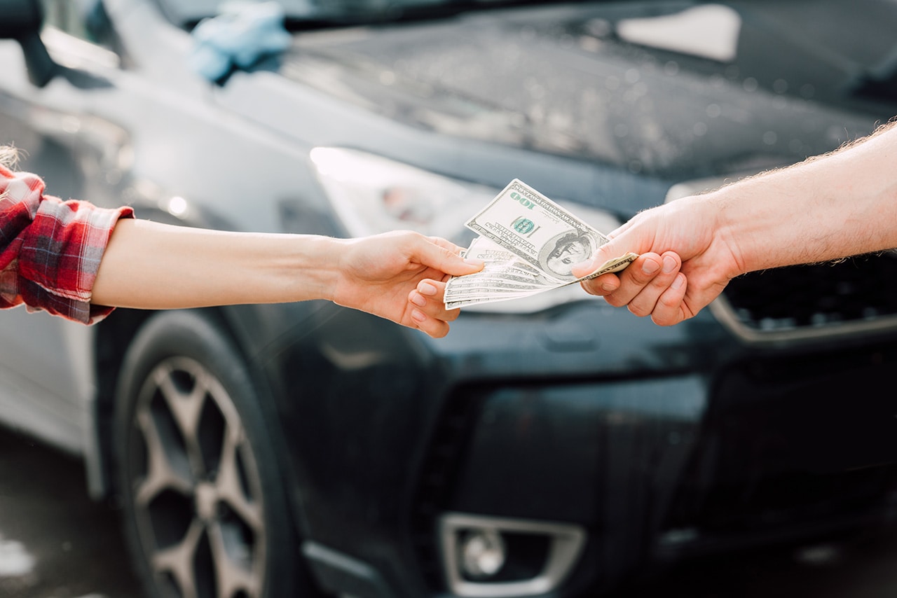 Hands with Money in front of Car