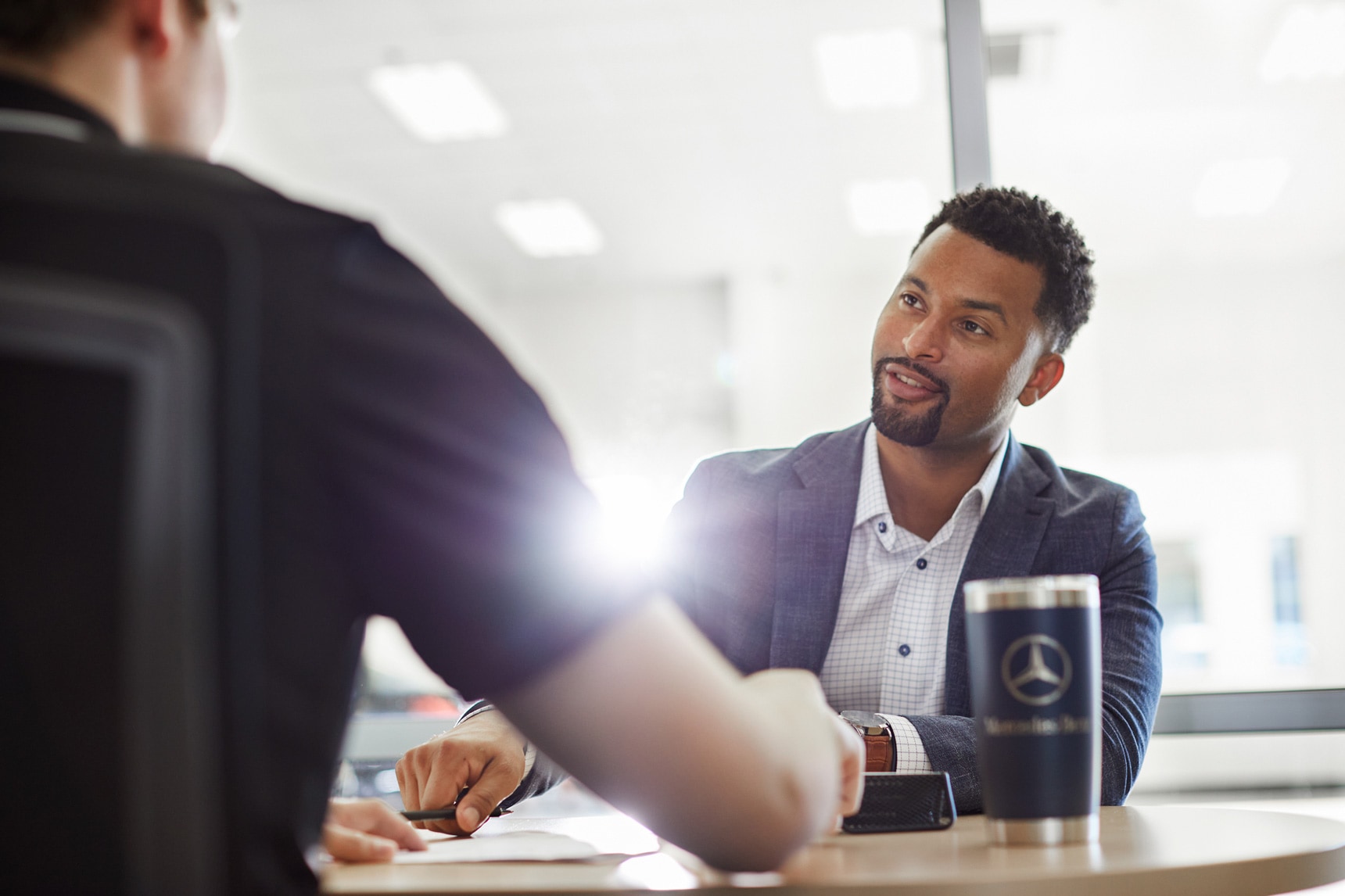 Customer meeting with a Mercedes-Benz finance specialist at a dealership desk