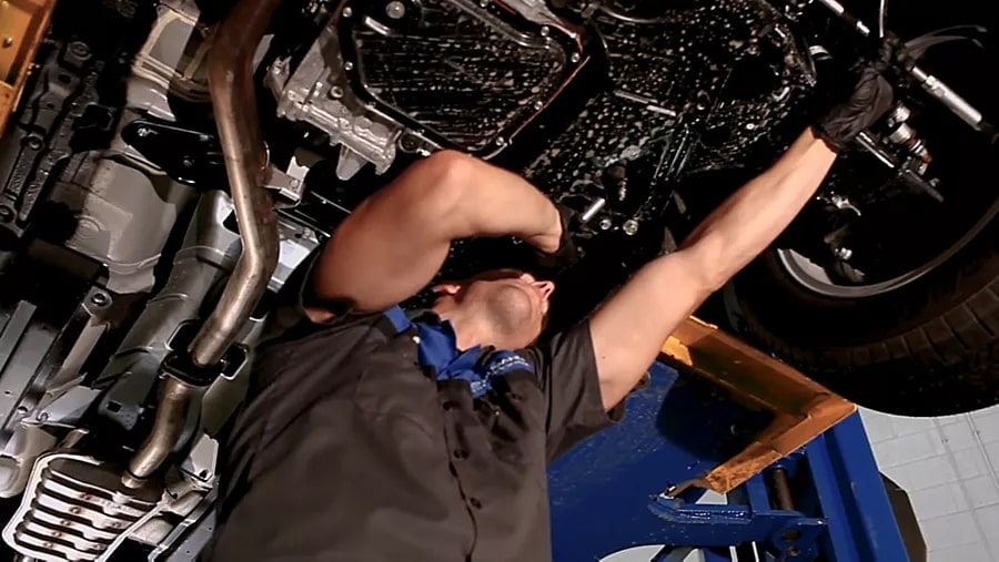 Subaru service technician working underneath vehicle