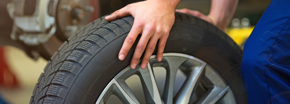 Mechanic hand on tire and wheel
