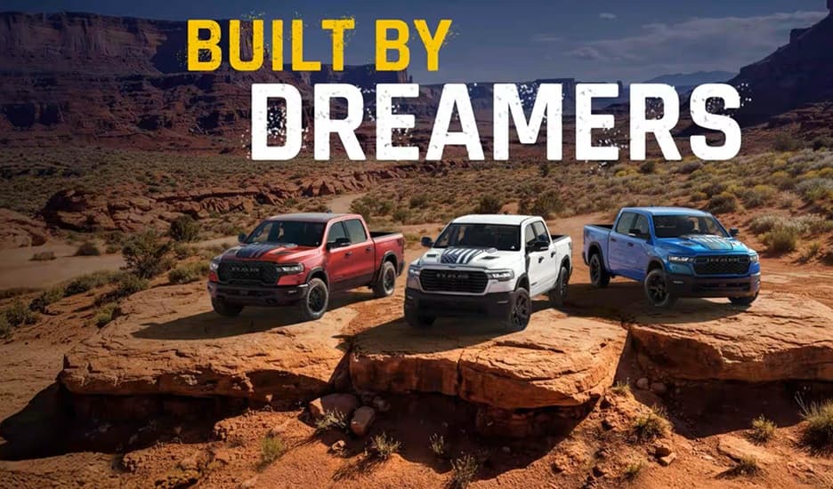 RAM pickup trucks posing on the edge of a rocky desert landscape
