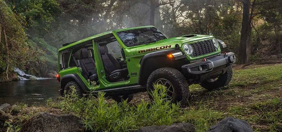 off-roading green 4-door jeep wrangler rubicon with the doors off
