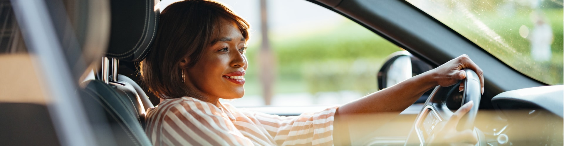 A lady happily driving her car