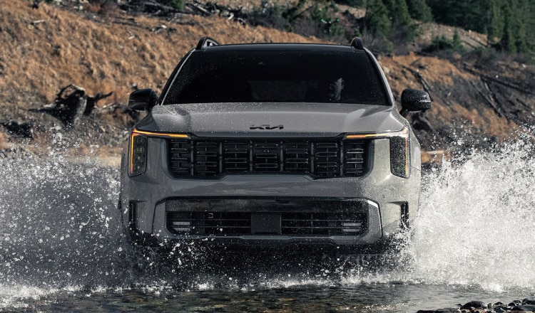 Kia SUV driving through a river