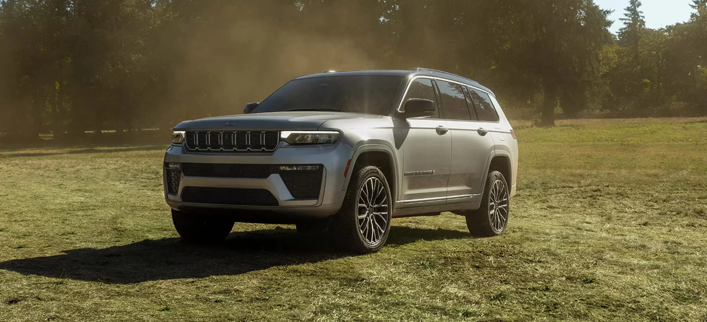 Front driver side angle of a silver 2026 Jeep Grand Cherokee Summit with the 2.0L Hurricane Turbo I4 engine