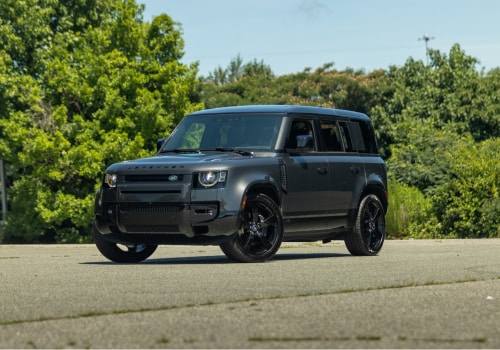 defender-110-for-sale.png Dark-colored 2025 Defender 110 parked on a paved surface with trees in the background