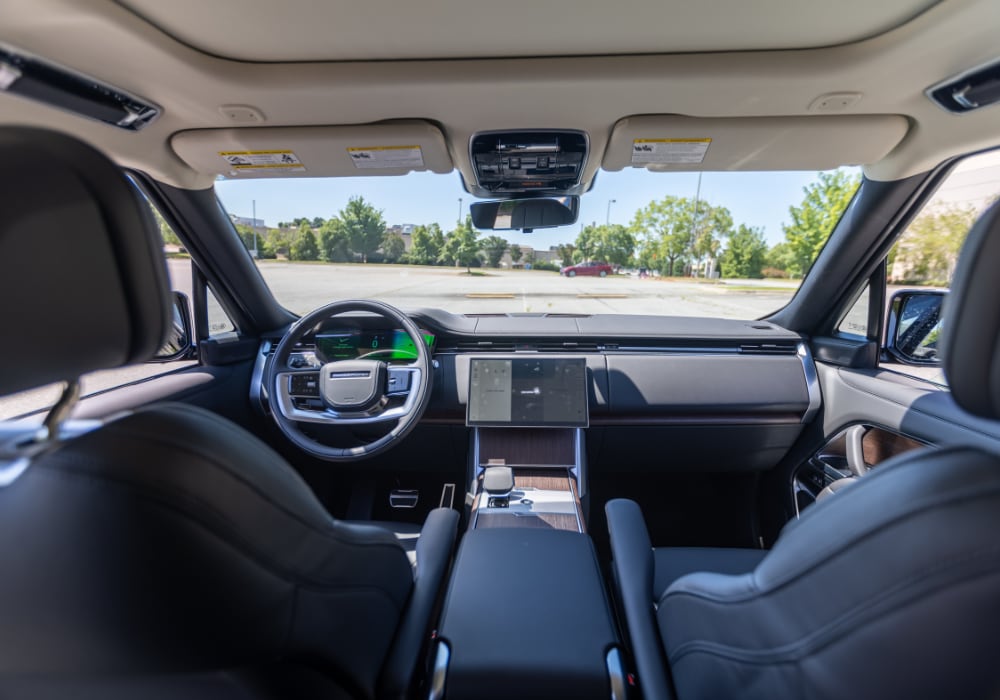 land-rover-range-rover-interior.png 2025 Land Rover Range Rover interior. The entire front dash is visible, including the infotainment system and steering wheel