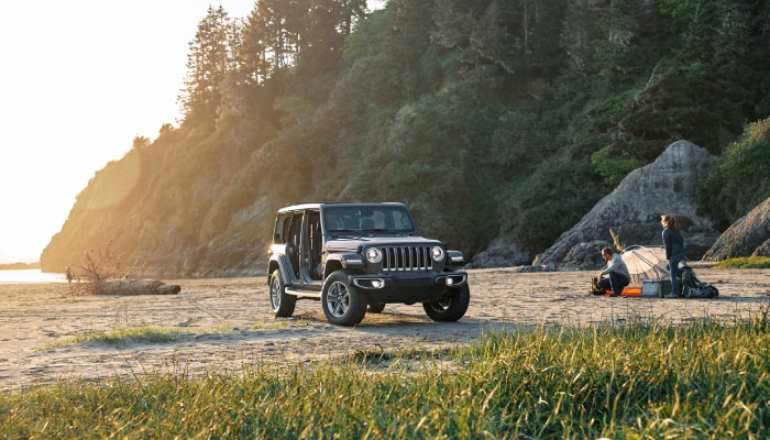 Jeep Wrangler on the beach with campers.