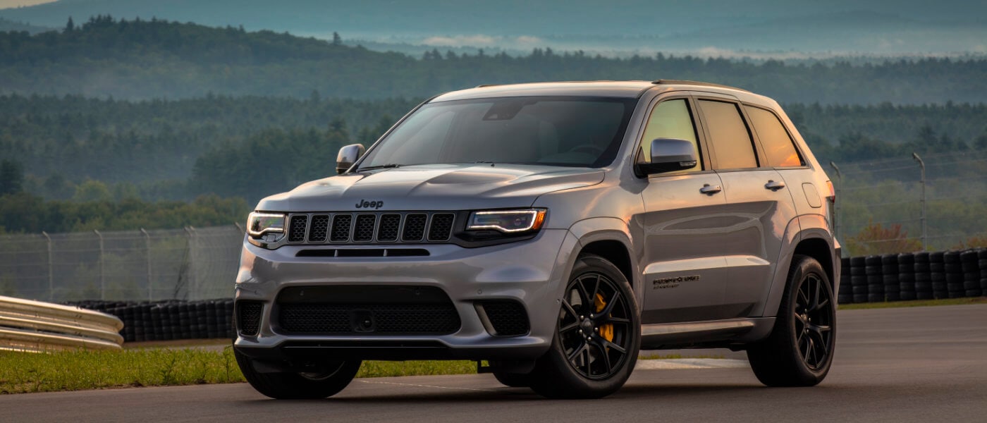 2020Jeep Grand Cherokee in gray parked on test track with mountians in the background