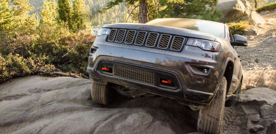 A 2018 Jeep Grand Cherokee climbing a rock