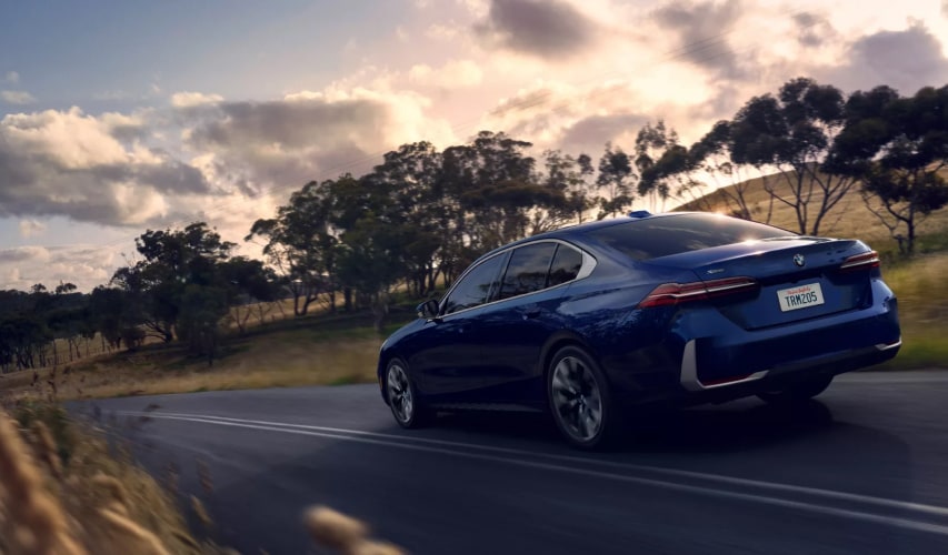 Blue BMW Sedan driving on the road