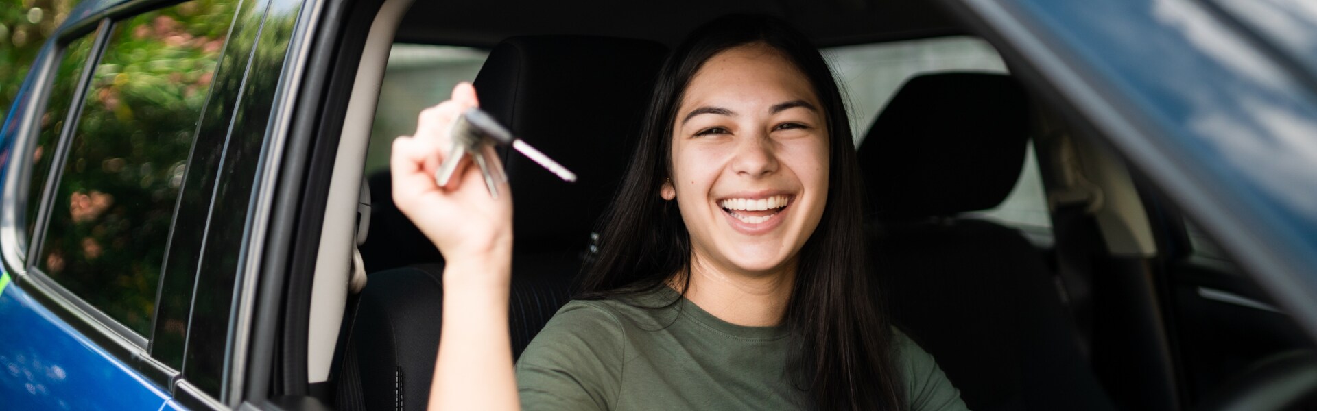 Woman presenting keys for the Blue Subaru SUV