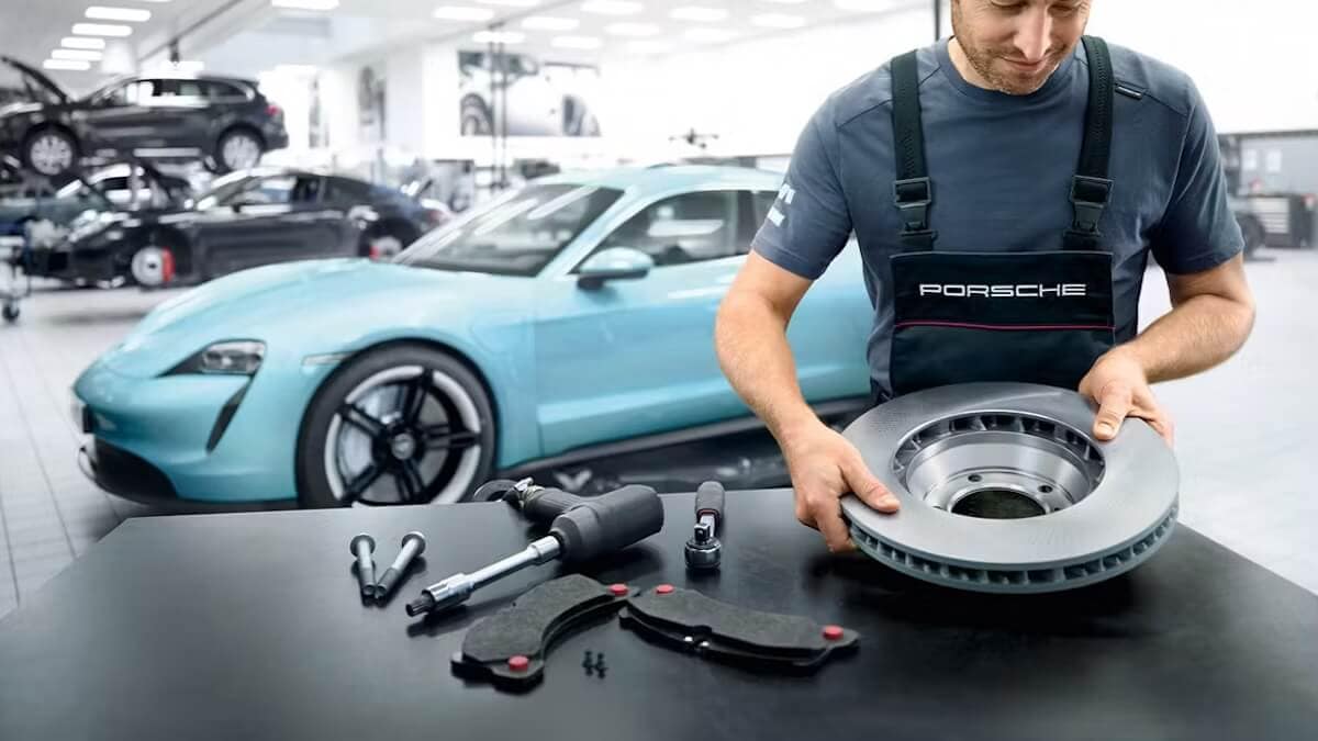 Porsche technician holding Porsche parts