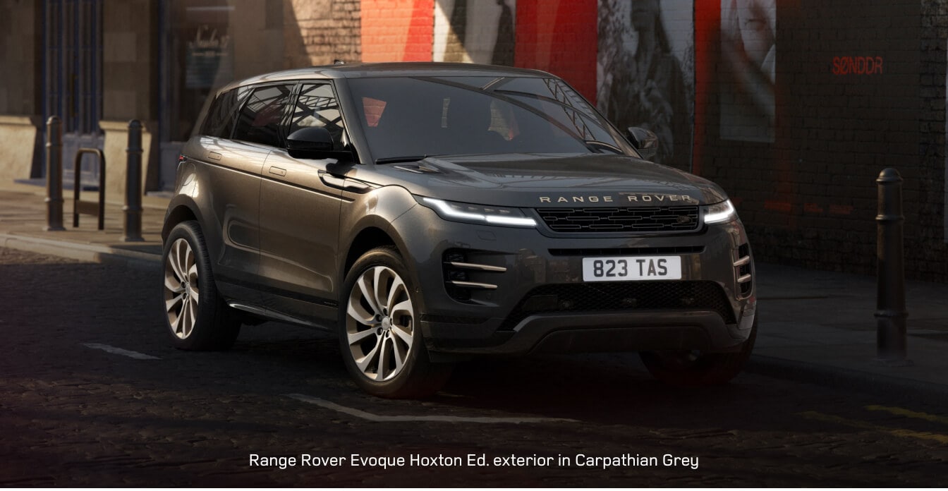 2026 Range Rover Evoque parks on a cobblestone street by a brick poster wall.