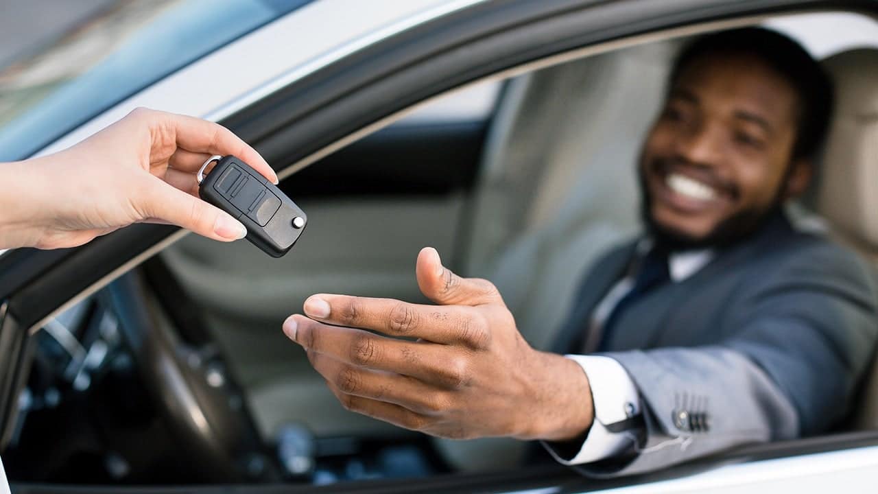 handing key to man in car