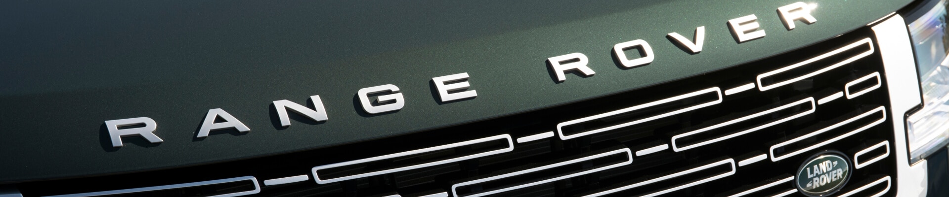 Range Rover highlights hood lettering and grille details in an outdoor setting.