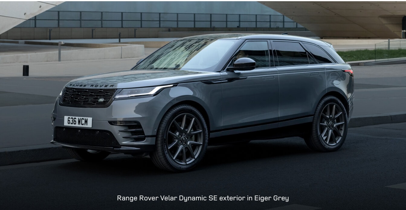 2026 Range Rover Velar idles beneath a modern archway on an urban street.