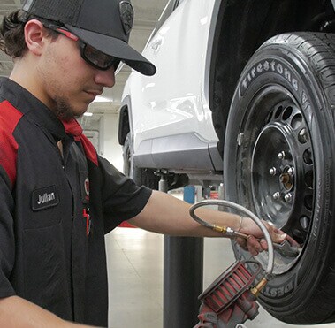  Service technician putting on a new Toyota tire.