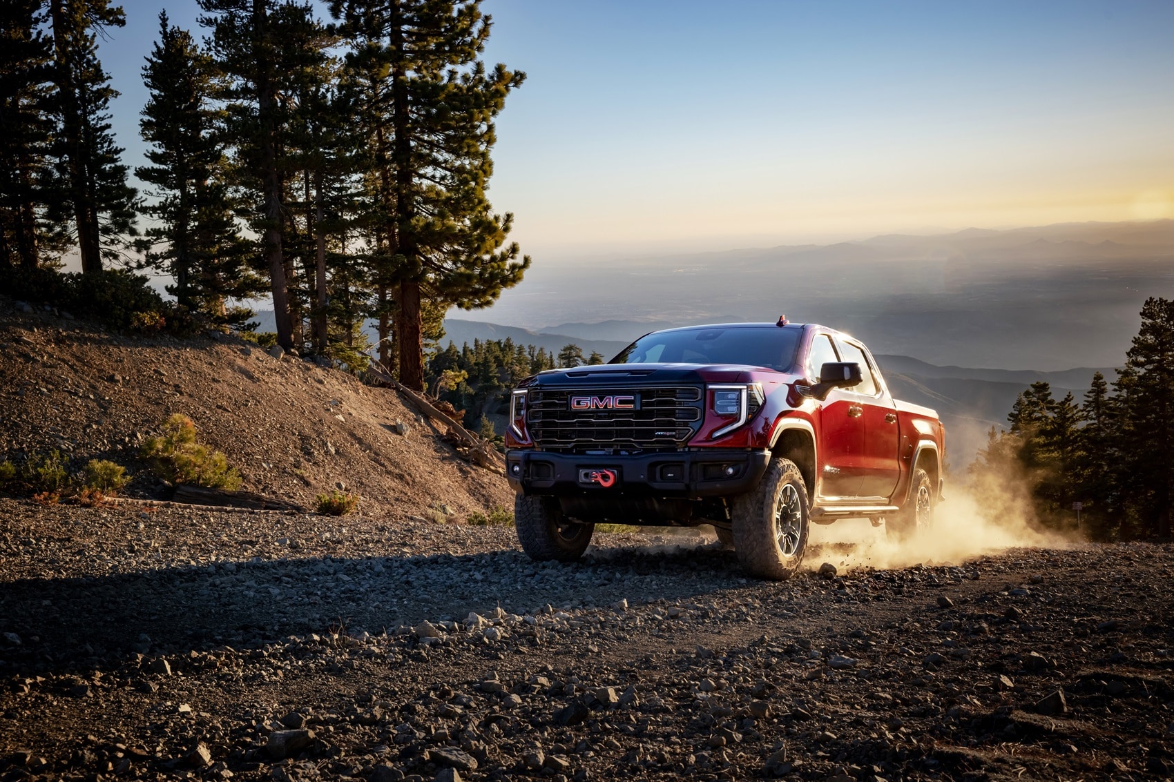 GMC Sierra 1500 parked on mountaintop with dirt kicked up around back tires