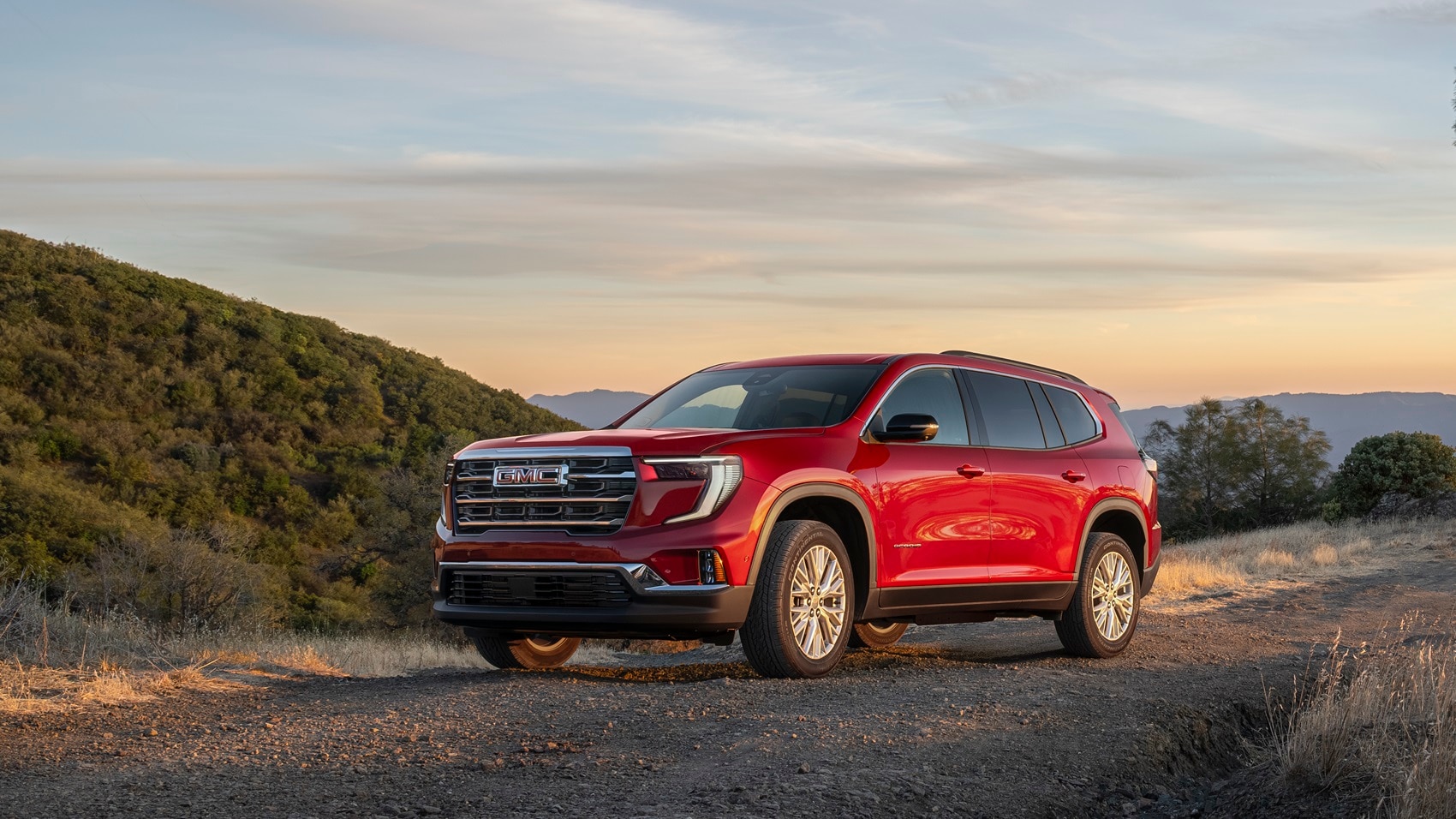 GMC Acadia SUV parked with sunset background