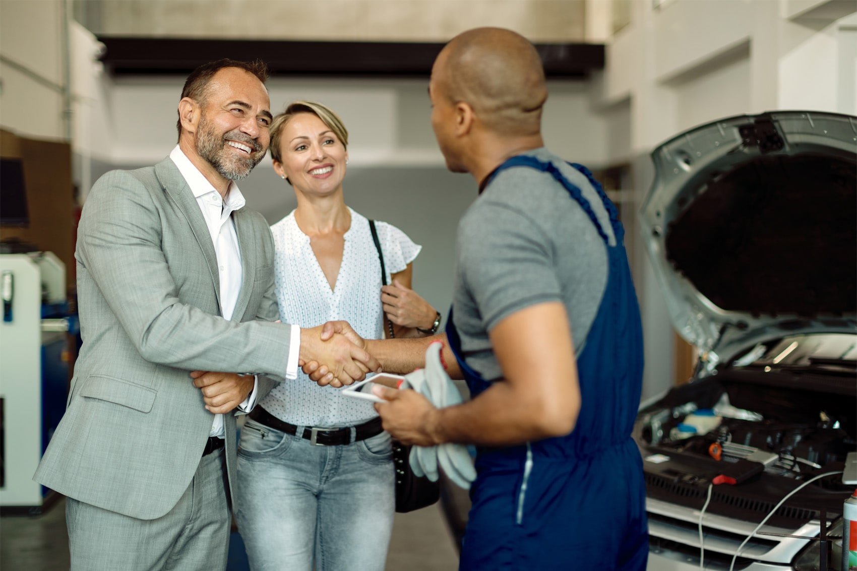 GMC Certified Technician shaking hands with a couple before discussing service maintenance