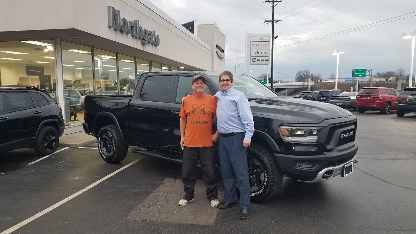 Man standing in front of newly bought pickup truck outside of Northgate CDJR