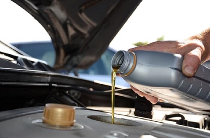 Mazda service technician changing car's oil