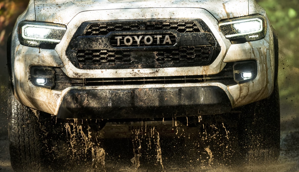 front shot of the toyota tacoma offroading in mud and majesty