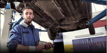 mechanic standing under a toyota
