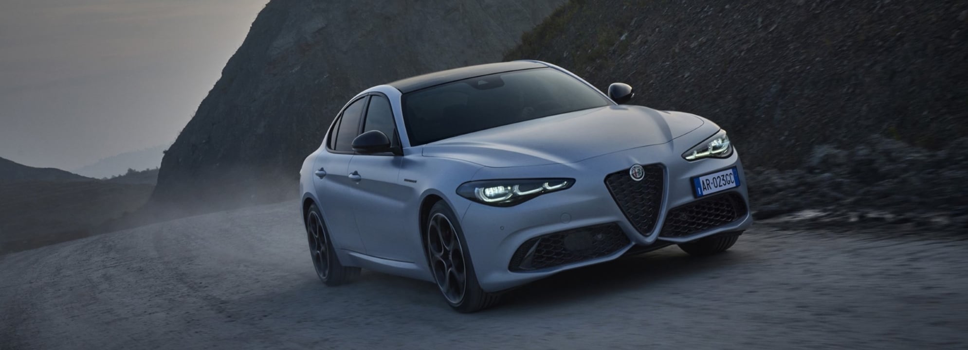 2024 Alfa Romeo Giulia driving on sandy roads at dusk