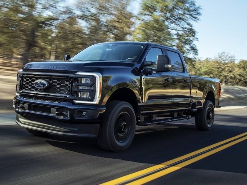 Ford Super Duty driving on scenic road with motion blur for Ford Section 179 qualifying vehicles