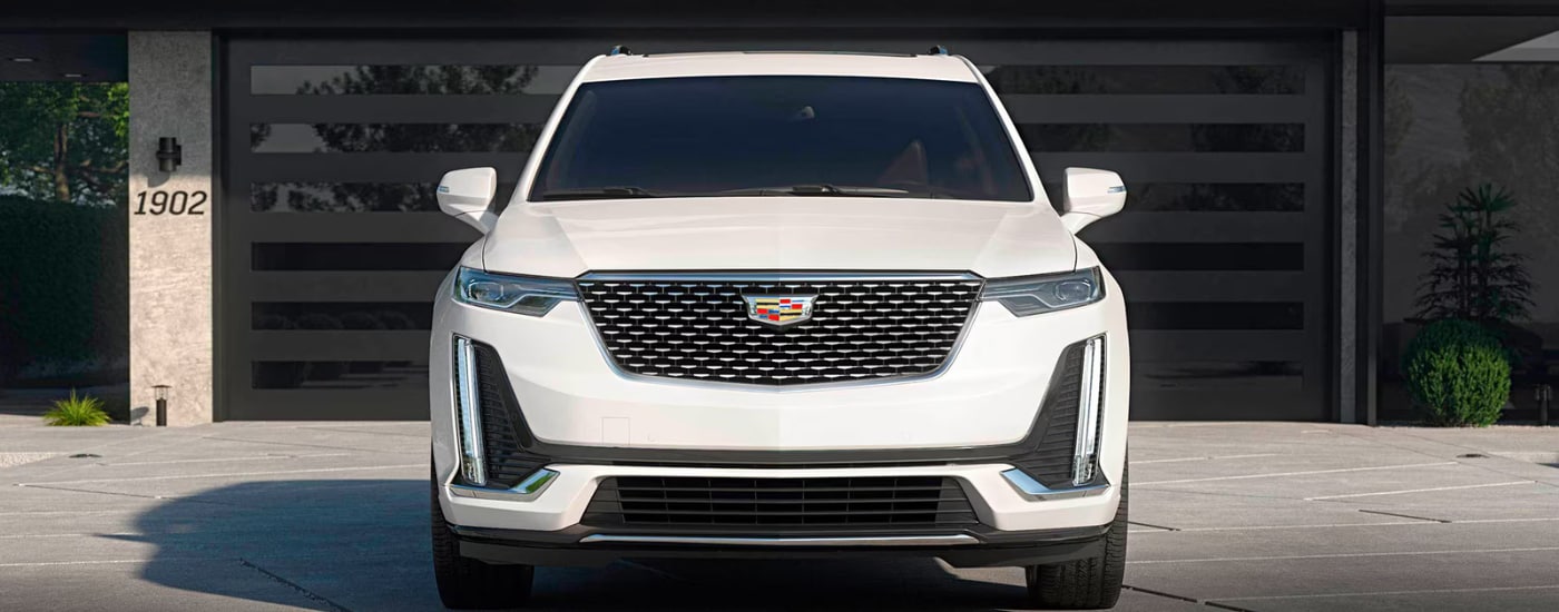 White 2026 Cadillac XT6 backed in in front of a garage