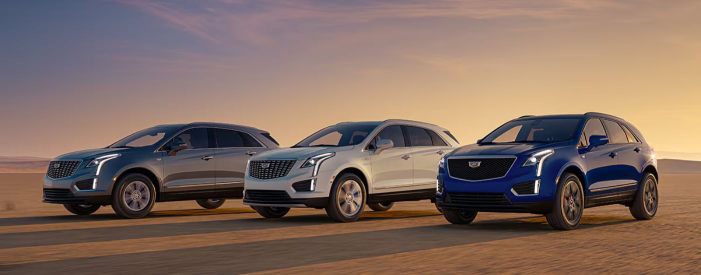 A Silver, a white, and a blue 2026 Cadillac XT5 parked together off-road