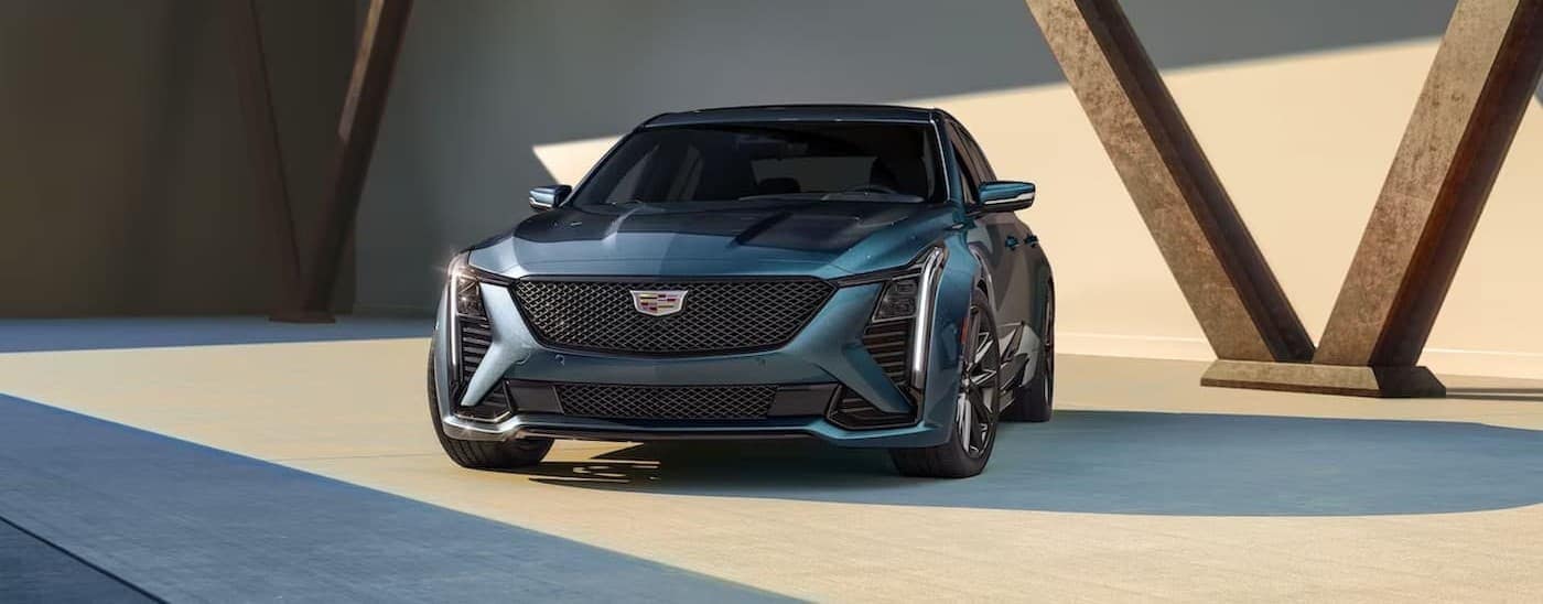 A green 2025 Cadillac CT5 parked near a Cadillac dealer in Miami.