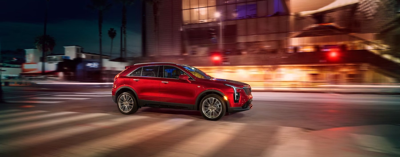a red 2024 Cadillac XT4 from the side after leaving a dealer that has a used Cadillac for sale in Miami.
