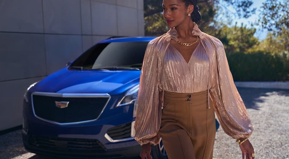 Person waliking near a blue 2026 Cadillac XT5.