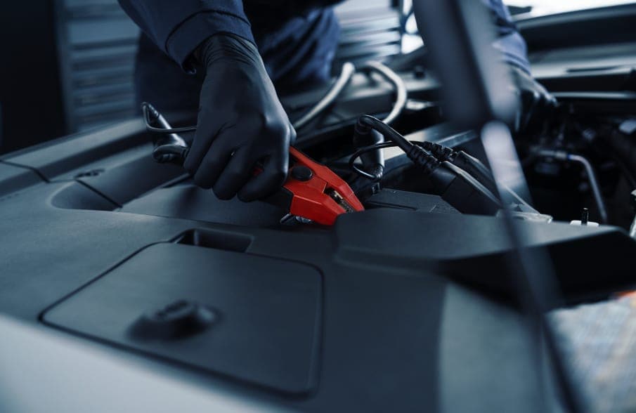Technician testing a Cadillac battery and charging system at Ocean Cadillac in Miami