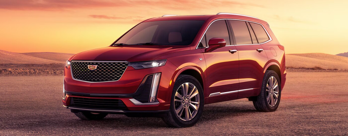 Red 2026 Cadillac XT6 parked off-road at an angle