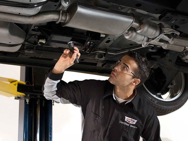Cadillac Certified Service technician performing an underbody inspection at Ocean Cadillac in Miami
