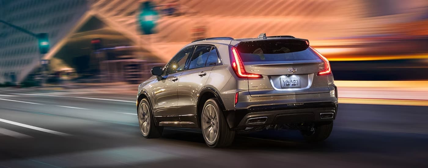 Grey 2024 used Cadillac XT4 for sale driving on a road.