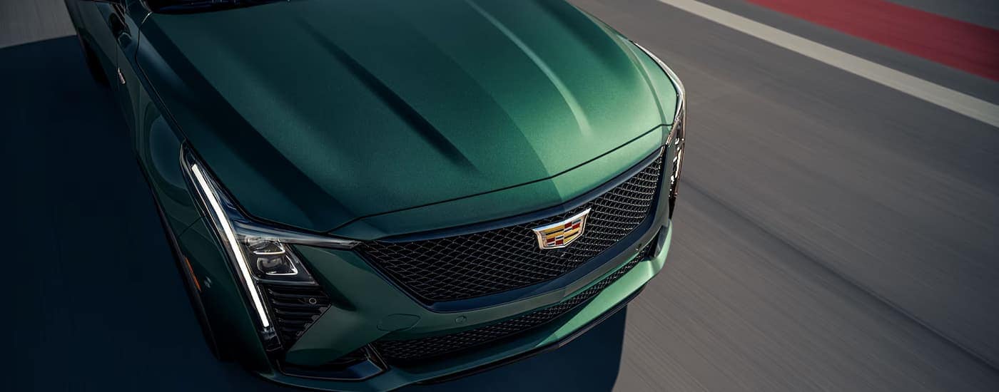 Front of a green 2025 Cadillac CT5-V driving on a track