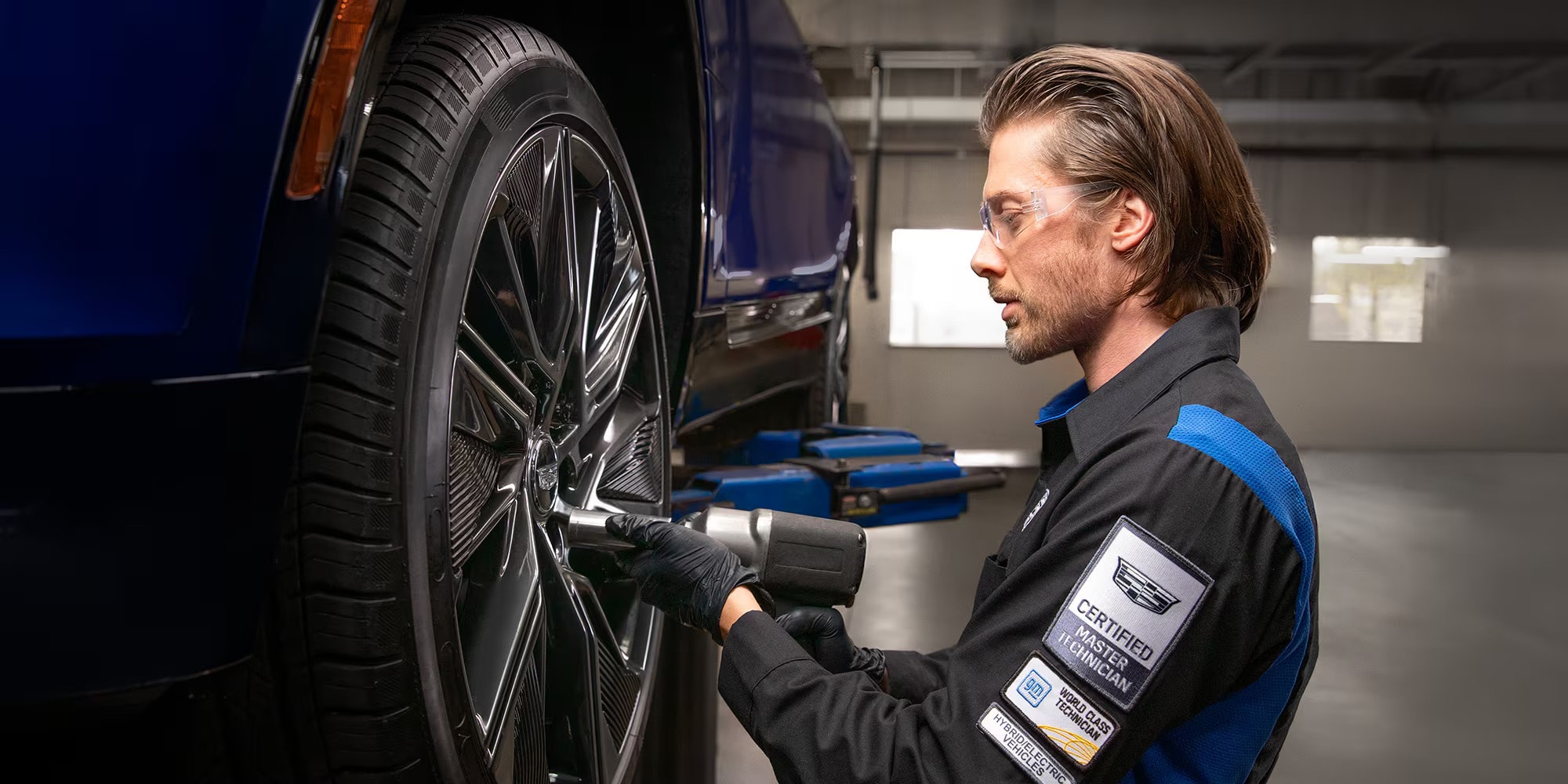 Technician rotating a tire on a Cadillac during service at Ocean Cadillac in Miami