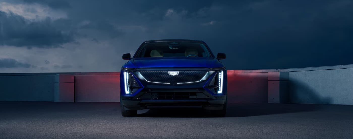 A blue 2026 Cadillac LYRIQ parked under a dark sky.