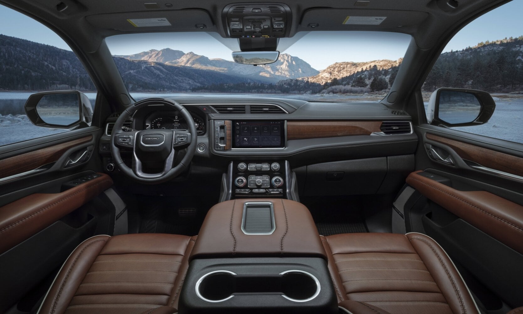 View of the front interior cabin inside the 2024 GMC Yukon Denali as seen from the rear 2nd row seating looking over the center console