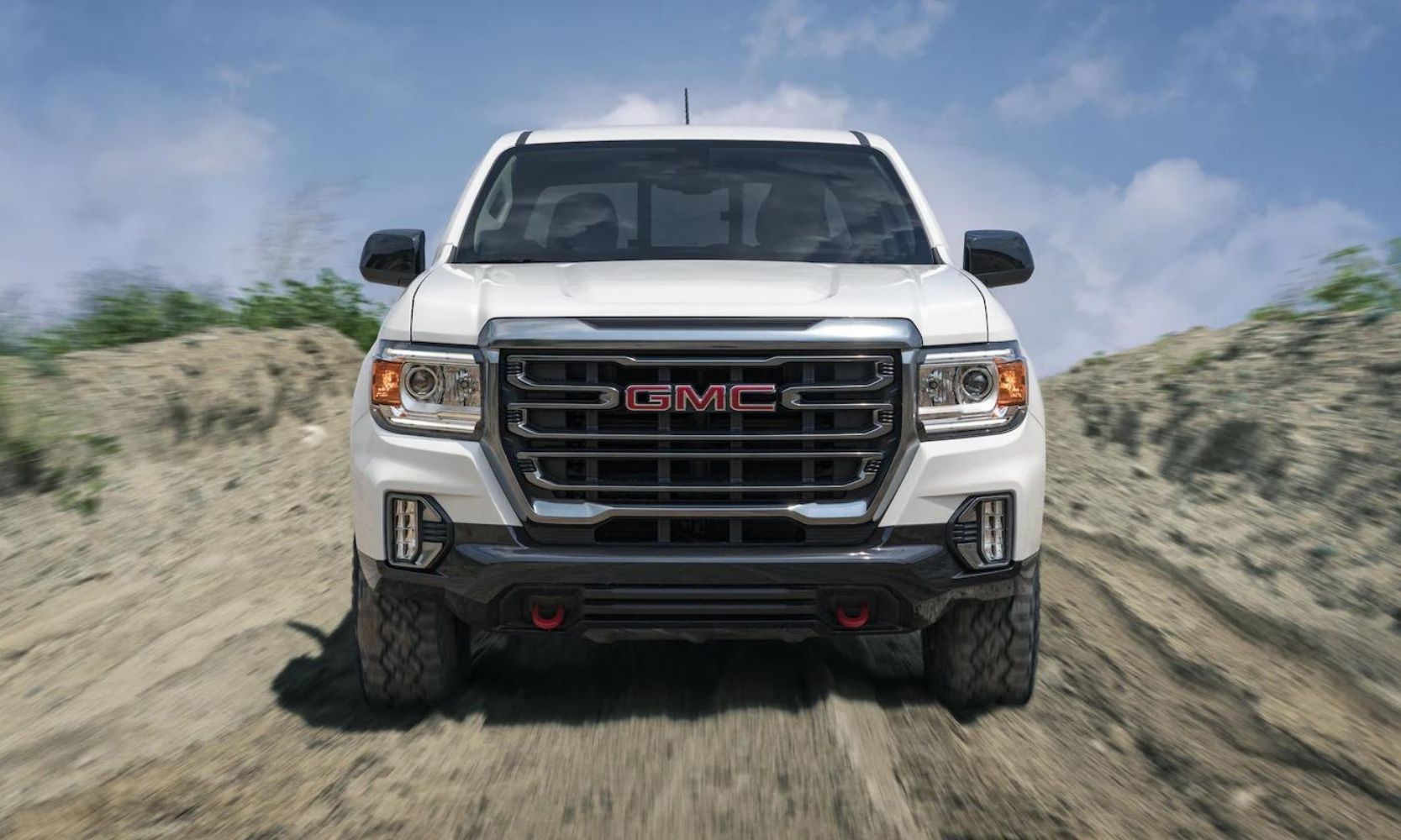 View of the front of a GMC Canyon driving on an off-road dirt trail