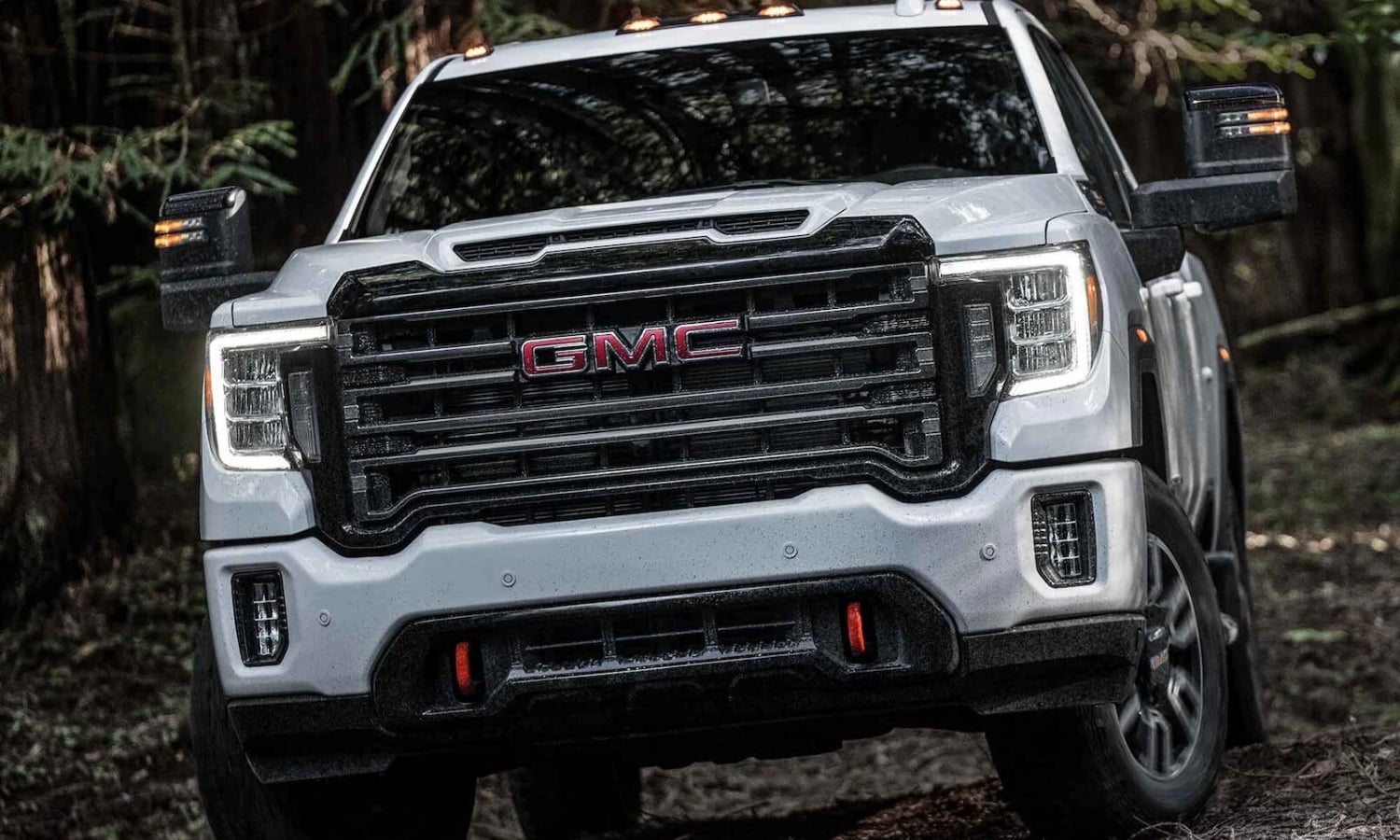 Close up profile view of a new 2022 GMC Sierra 2500HD AT4 off-road truck in white exterior color