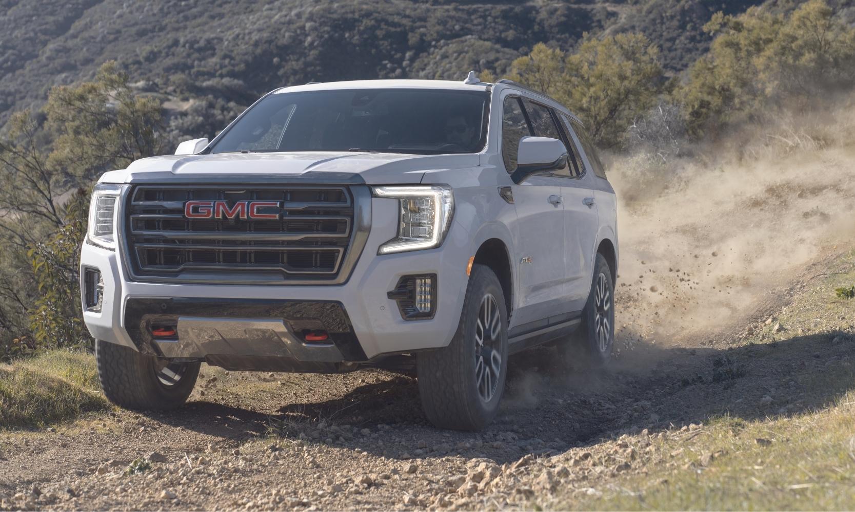 New 2023 GMC Yukon AT4 driving down an off-road trail toward the camera lens