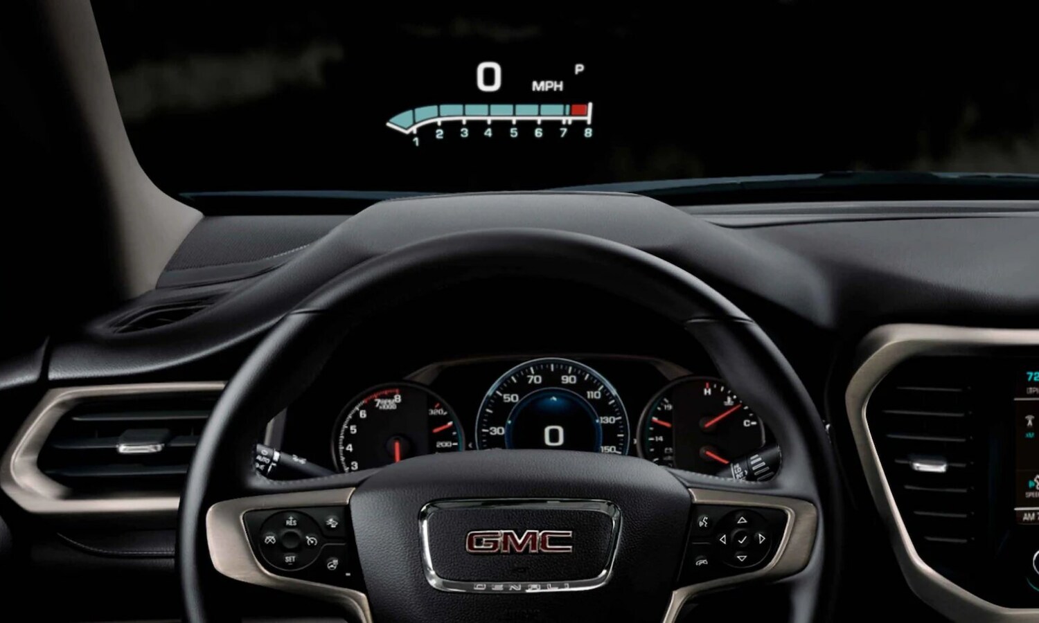 Close up view of the head up display and digital instrument panel behind the steering wheel inside the 2022 GMC Acadia SUV